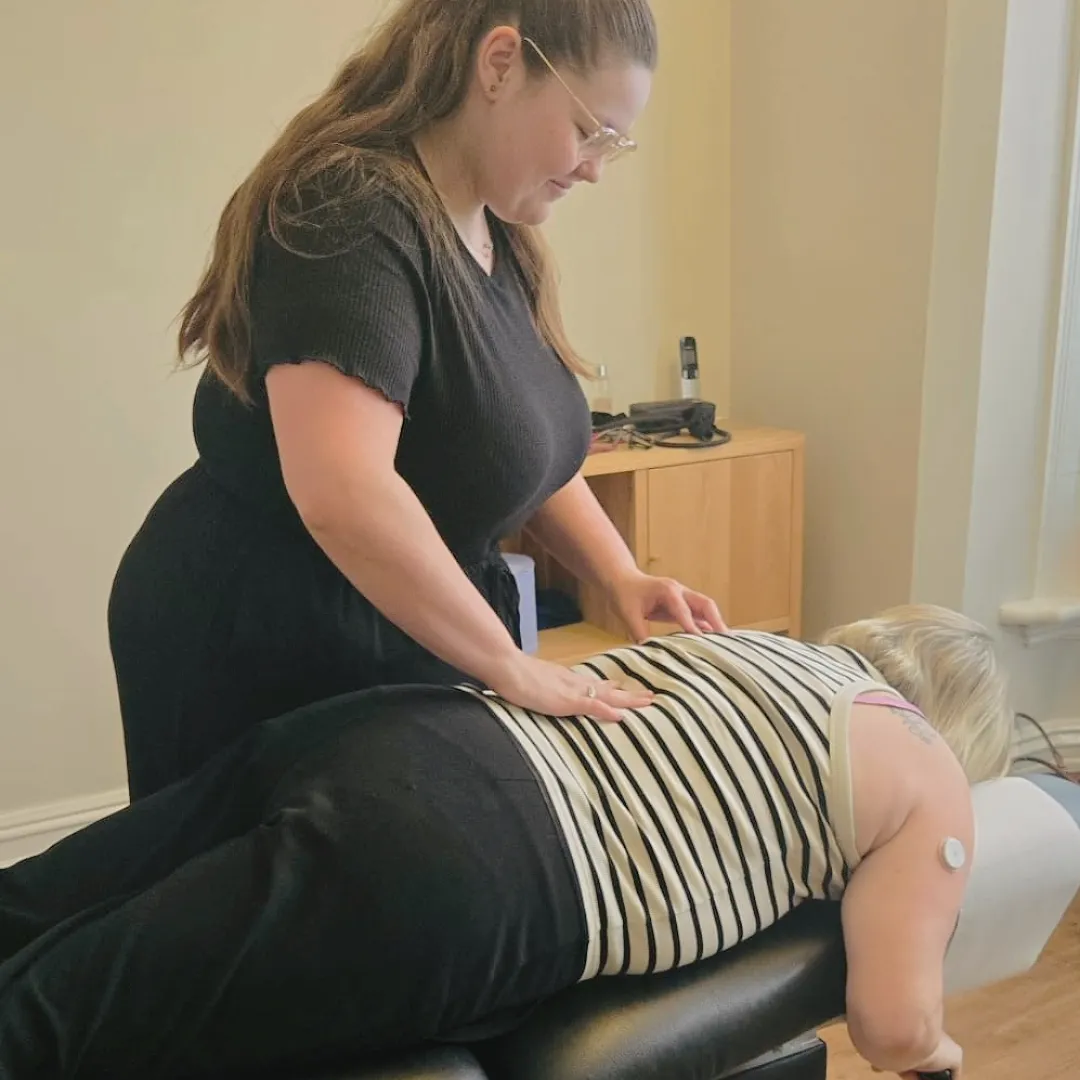 Chiropractor adjusting patient's back on a table.